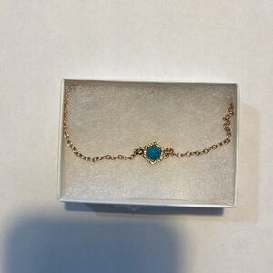 Gold anklet with blue stone surrounded by diamonds